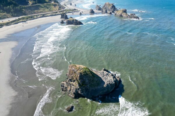 Scenic view of the Oregon Coast Road Trip 101 with cliffs, ocean waves, and sunset—perfect for a road trip adventure.
