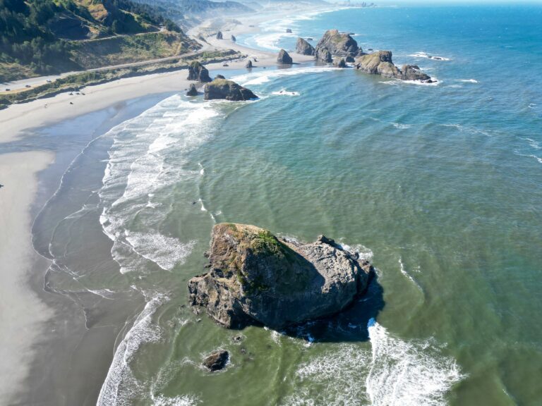Scenic view of the Oregon Coast Road Trip 101 with cliffs, ocean waves, and sunset—perfect for a road trip adventure.